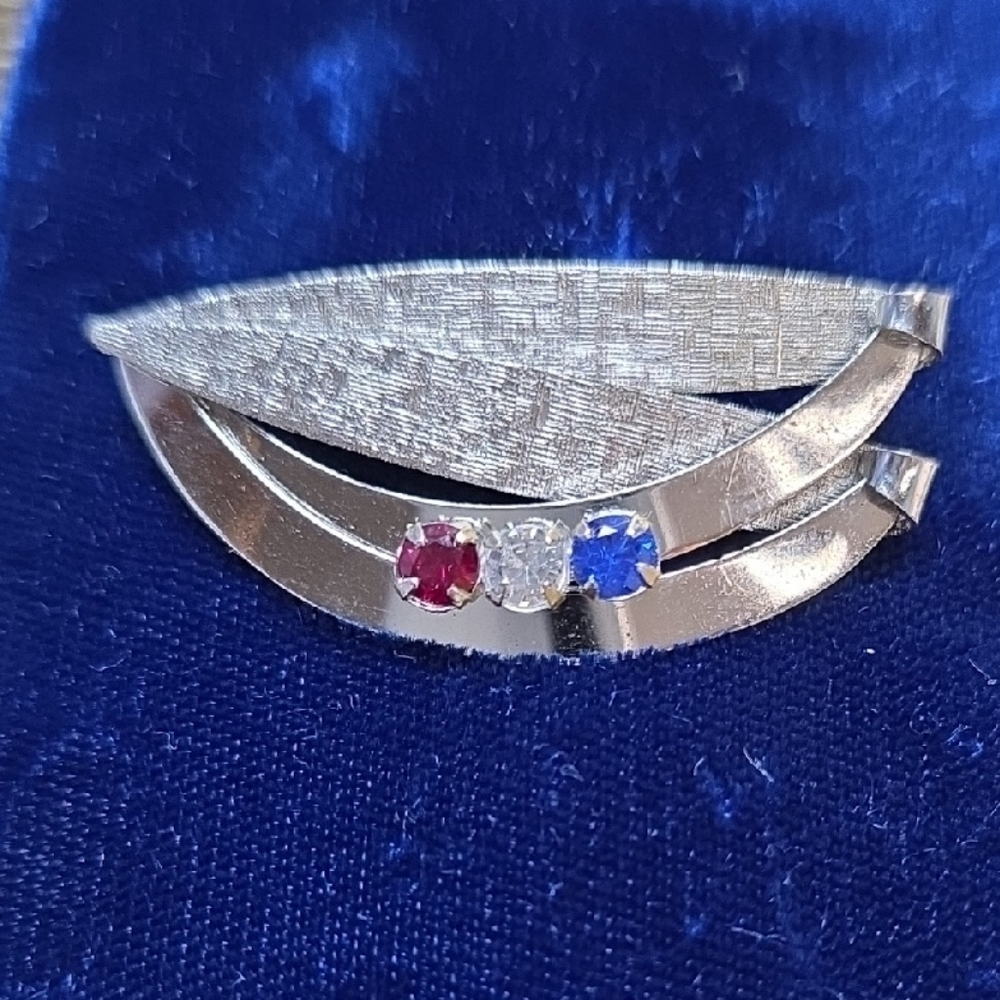 Elegant Silver Brooch with Red and Blue Accents